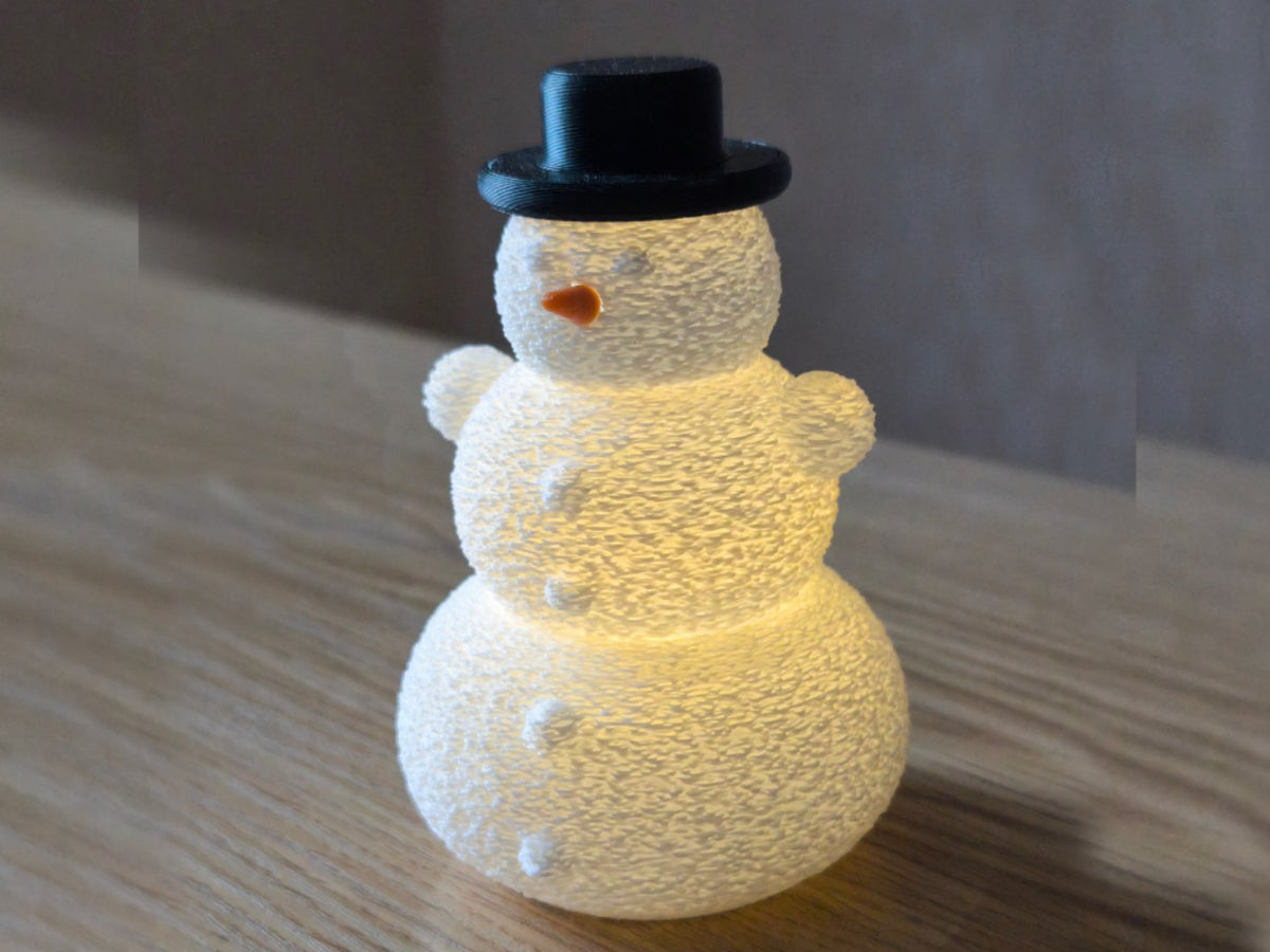 Sneeuwpop met hoed en neus over een led-theelichtje
