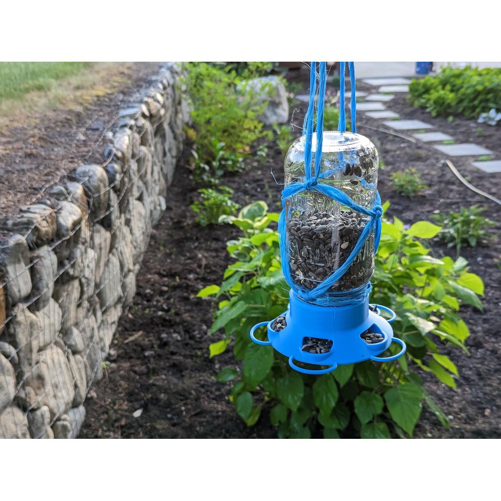 Schroefdeksel dat van een mason jar een voedersilo voor vogels in de tuin maakt
